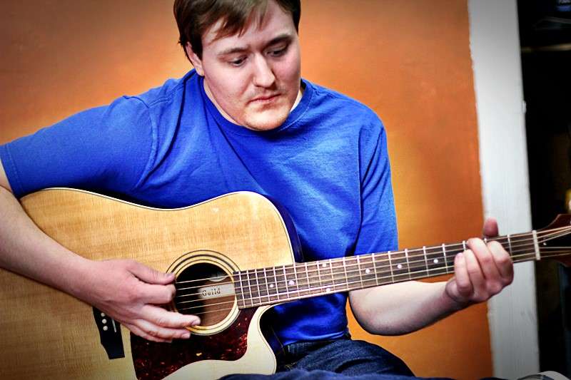 A student, Allan, playing the guitar.