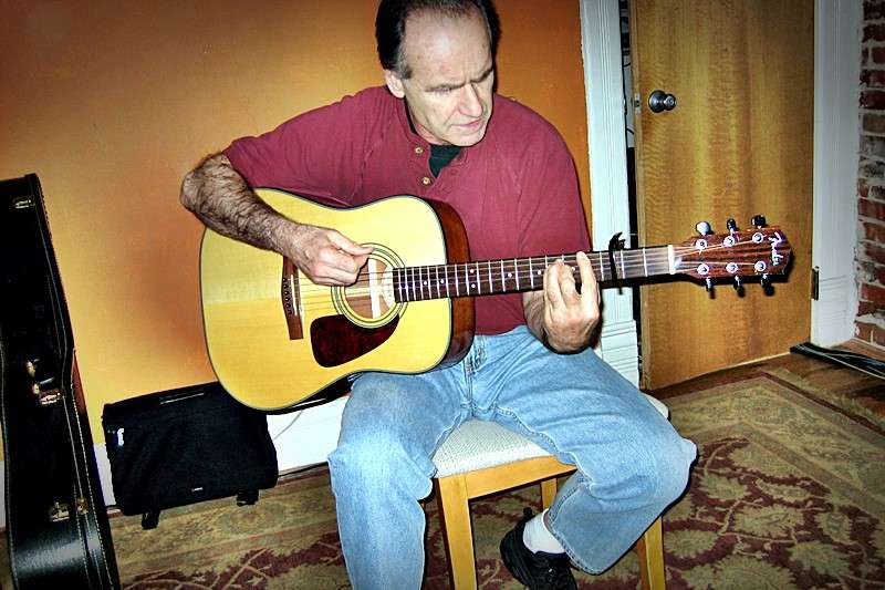 A student, Frank, playing the guitar.